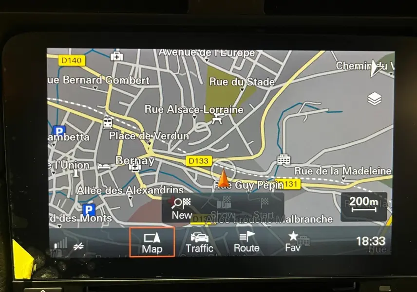 Écran tactile de navigation GPS affichant une carte routière détaillée en intérieur de véhicule.