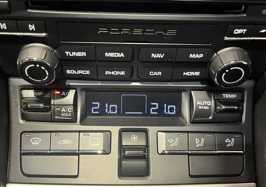 Tableau de bord Porsche 911 GT3 2018, zoom sur commandes climatisation et système audio noir mat.