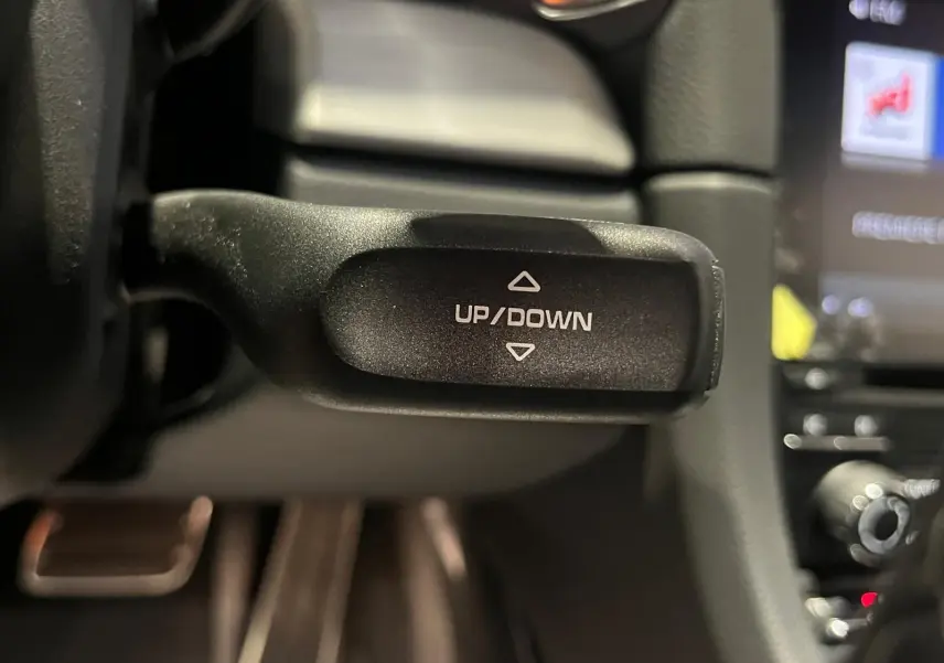 Gros plan sur la commande UP/DOWN du volant sport alcantara de la Porsche 911 GT3 2018, intérieur noir.