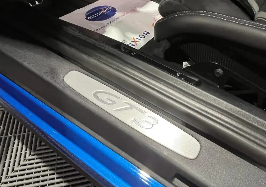 Seuil de porte GT3 en aluminium sur Porsche 911 GT3 bleu saphir, avec siège baquet carbone visible.