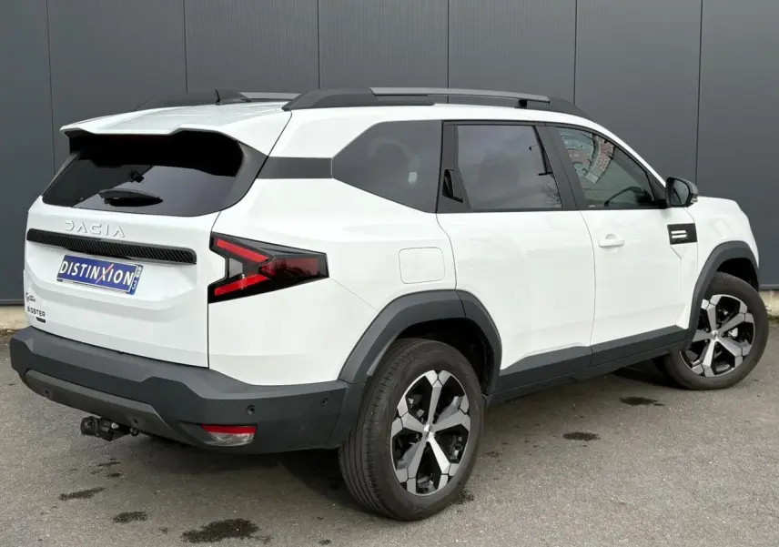 Vue 3/4 arrière droite du Dacia Bigster blanc Banquise avec attelage démontable et jantes alliage 18 pouces.