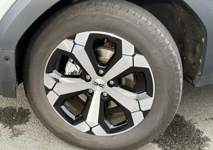 Gros plan sur la jante alliage diamantée 18 pouces du Dacia Bigster blanc Banquise, avec pneu Continental.