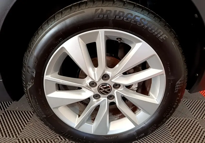 Gros plan sur la jante alliage argentée et pneu Bridgestone du Volkswagen T-Cross noir, côté roue avant.