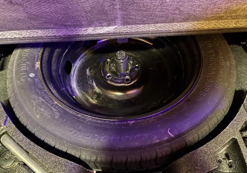Gros plan sur la roue de secours noire dans le coffre d’un Skoda Kodiaq bleu 2023, version diesel 7 places.