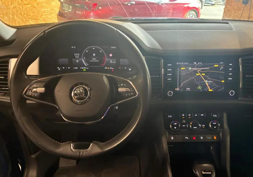 Vue intérieure centrée sur le volant et le tableau de bord numérique d’un Skoda Kodiaq 2023 avec écran tactile et commandes au volant.