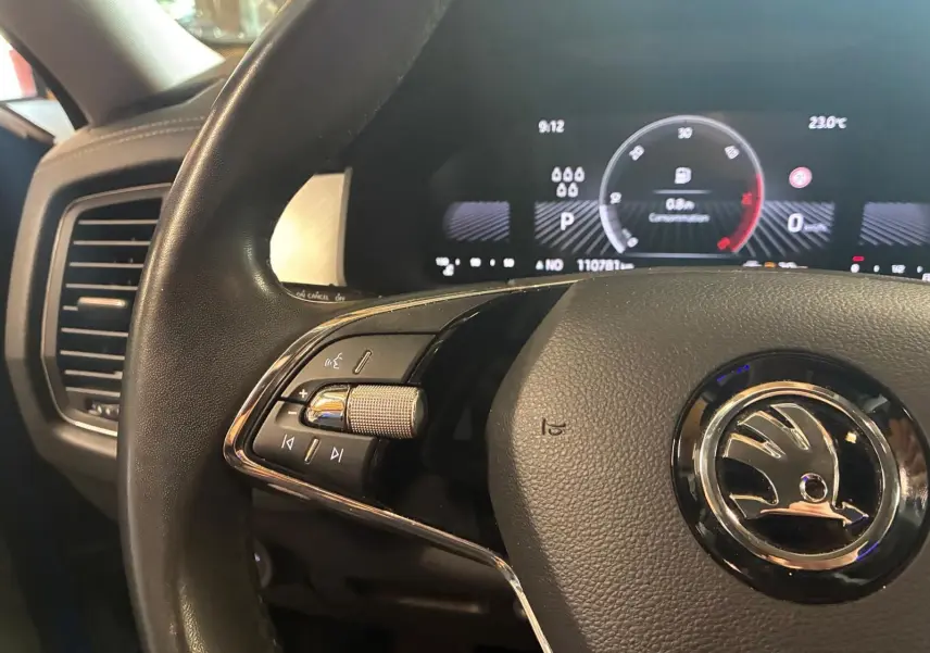 Gros plan sur le volant noir de la Skoda Kodiaq 2023 avec commandes intégrées et tableau de bord digital en arrière-plan.