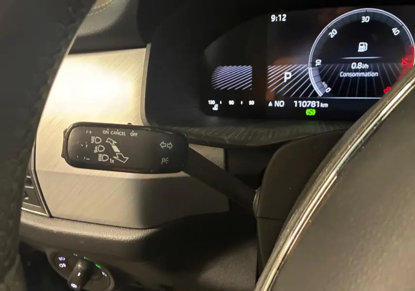 Gros plan sur le compteur et la commande de clignotant à gauche dans l’habitacle d’un Skoda Kodiaq bleu 2023.