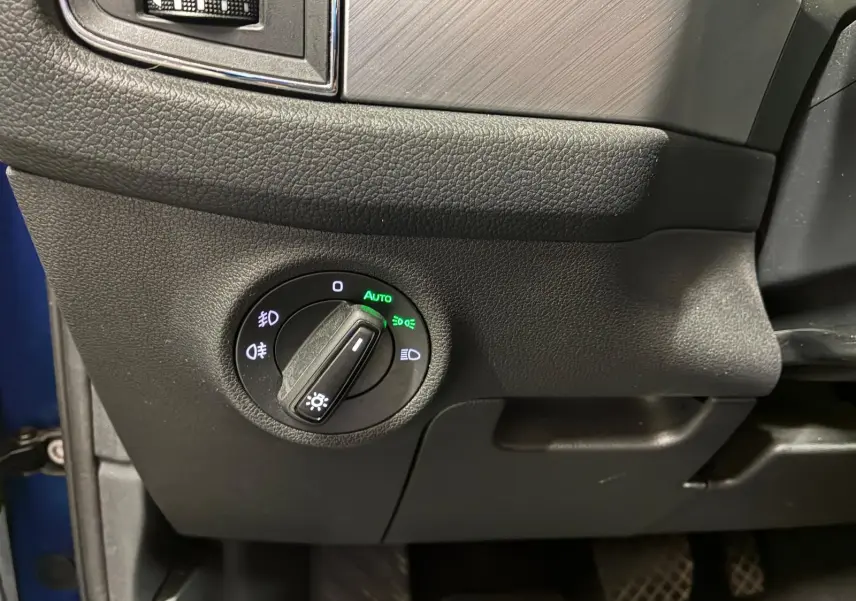 Détail du bouton de commande des phares sur le tableau de bord côté gauche d’un Skoda Kodiaq bleu 2023.