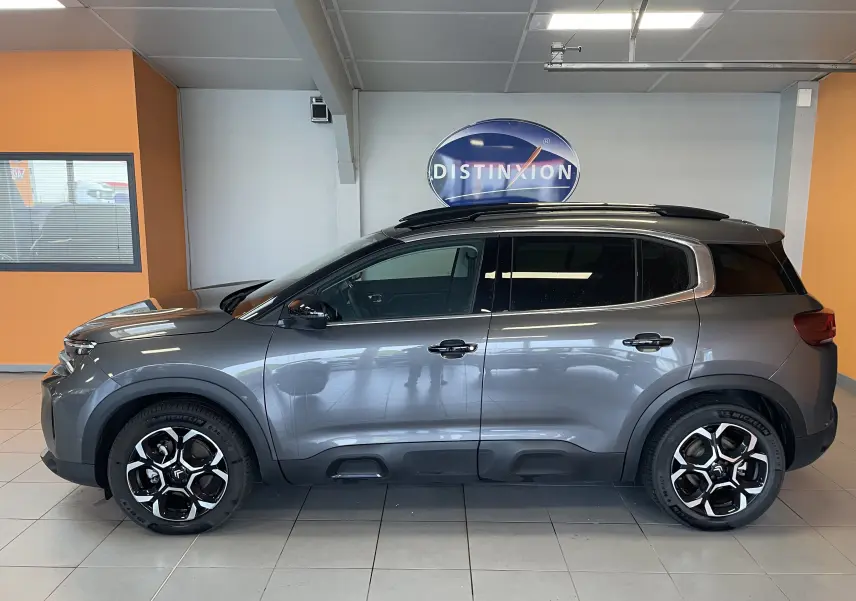 Vue de profil côté gauche d'un Citroën C5 Aircross hybride gris platinium avec jantes alliage 18 pouces biton noir.