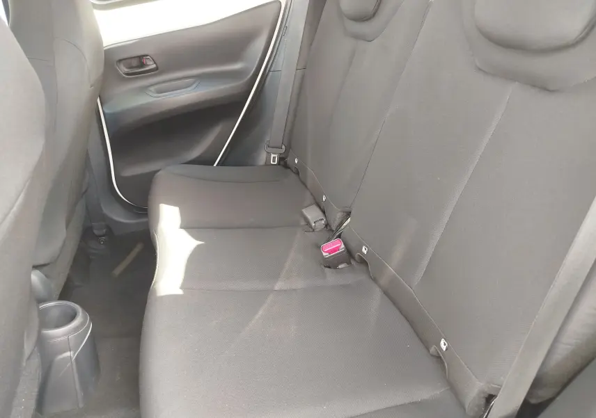 Vue intérieure côté droit des sièges arrière noirs d'une Toyota Aygo X 2023, avec ceinture et boucle de sécurité visibles.