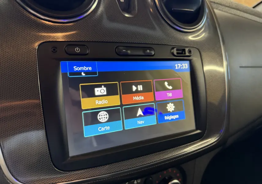 Écran tactile central de la Dacia Sandero Stepway bleu 2019, vue rapprochée du système multimédia avec menus colorés.