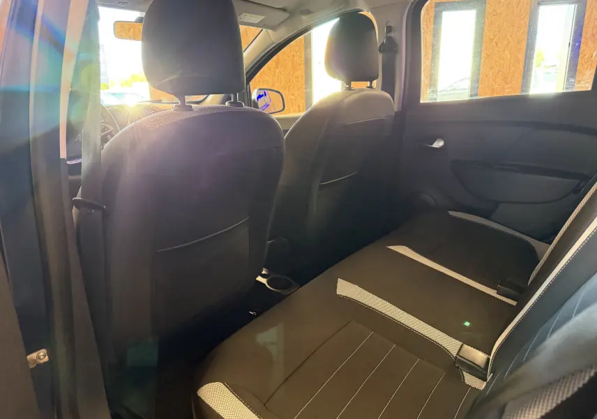 Vue intérieure arrière de la Dacia Sandero Stepway 2019, montrant les sièges noirs avec inserts gris.