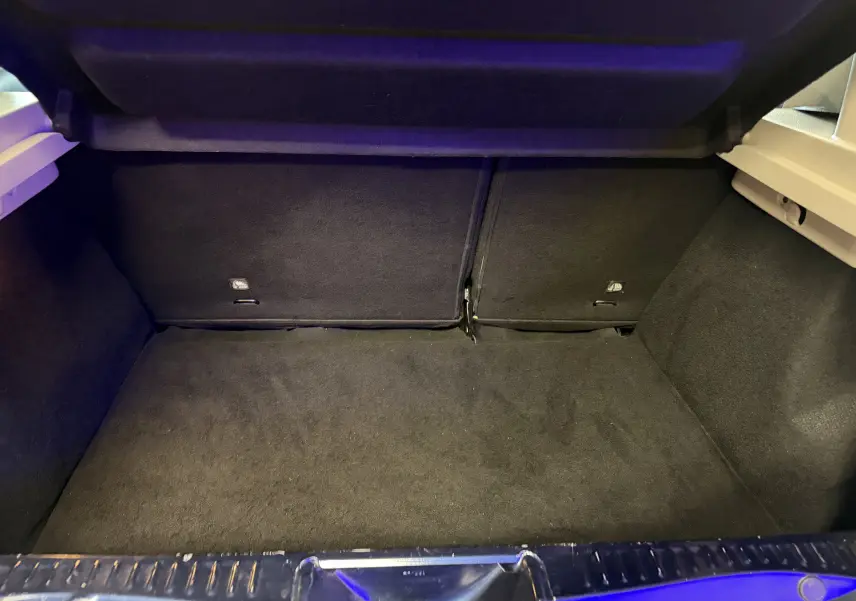 Coffre ouvert vu de l'arrière d'une Dacia Sandero Stepway 2019 bleu, montrant l'espace de chargement vide.