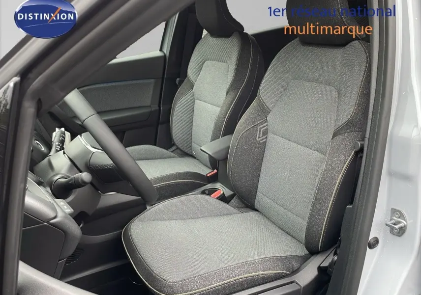 Vue intérieure côté conducteur du Renault Captur E-Tech gris Rafale avec sièges tissu gris et beige, volant et tableau de bord visibles.