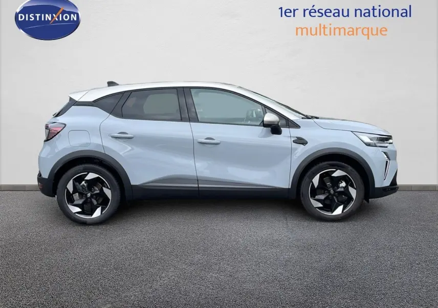 Profil droit d'un Renault Captur 2025 hybride gris rafale avec toit beige et jantes noires bicolores.
