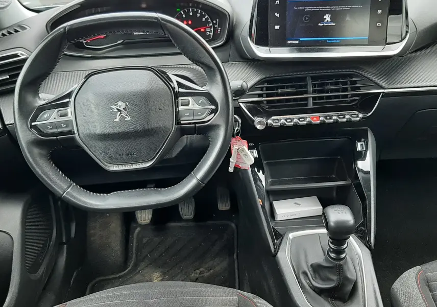 Vue intérieure du tableau de bord du Peugeot 2008 2020, volant compact, écran tactile central et levier de vitesses manuel.