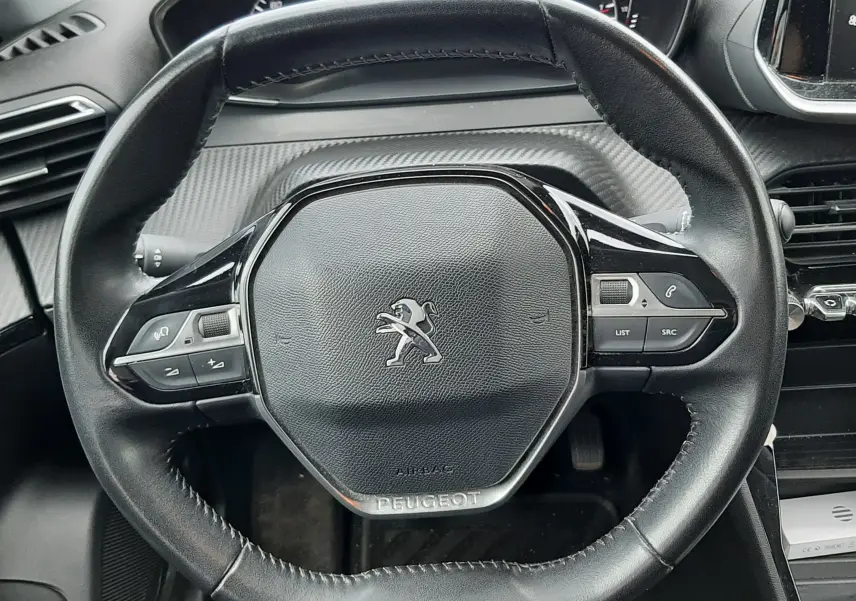 Vue rapprochée du volant cuir noir de la Peugeot 2008 2020 avec commandes intégrées et tableau de bord partiel.