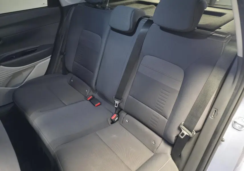 Vue intérieure côté arrière droit montrant la banquette arrière grise du Hyundai Bayon 2025 avec ceintures de sécurité visibles.