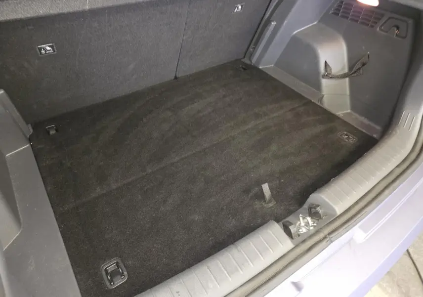Coffre ouvert vu de dessus du Hyundai Bayon gris, montrant le plancher plat et les fixations de chargement.