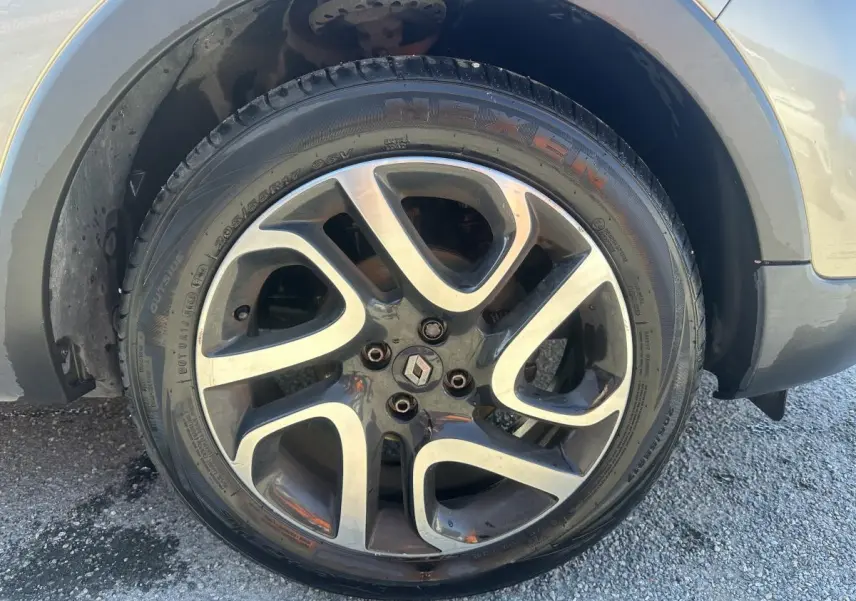 Gros plan sur la roue avant gauche du Renault Captur beige, jante alliage noir diamanté 17 pouces.