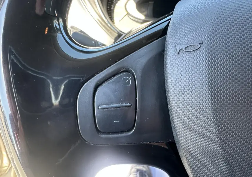Gros plan sur le volant noir et ses commandes intégrées du Renault Captur beige, version Intens 2014.