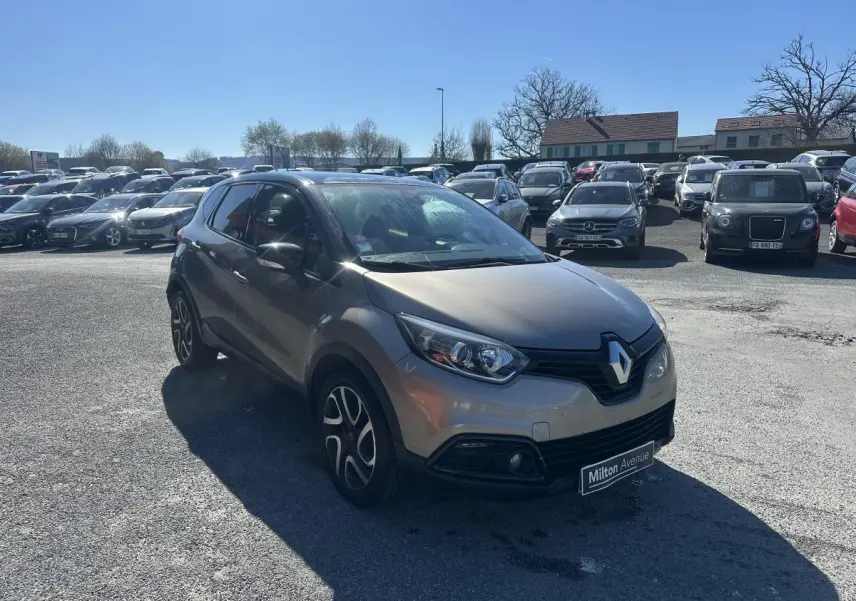Renault Captur beige métallisé en 3/4 avant droit, avec jantes alliage noires et toit bi-ton noir.