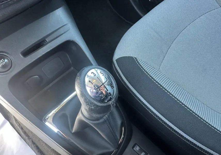 Gros plan sur le levier de vitesses manuel et la sellerie tissu gris et noir du Renault Captur beige 2014.