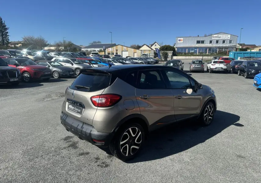 Renault Captur beige métallisé vue 3/4 arrière droit, toit noir et jantes alliage noires diamantées.