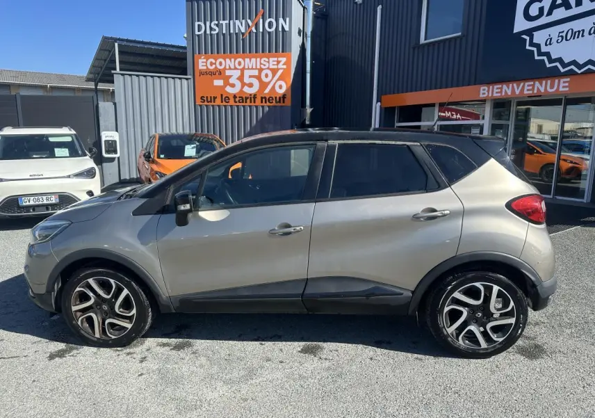 Vue latérale droite d'un Renault Captur beige métallisé avec toit noir et jantes alliage noires diamantées.
