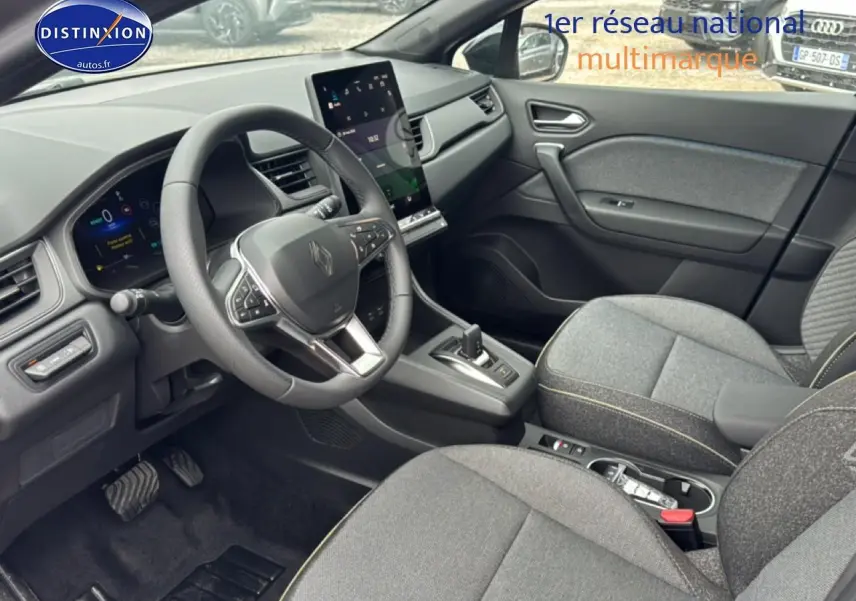 Vue intérieure côté conducteur du Renault Captur gris cassiopée, volant multifonction et écran tactile vertical au centre.