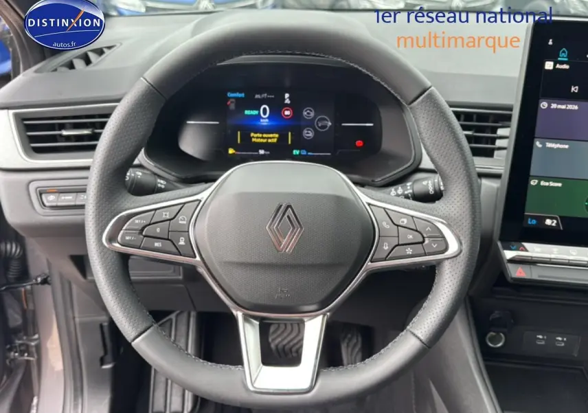 Vue intérieure centrée sur le volant noir perforé du Renault Captur 2026 avec tableau de bord numérique et écran tactile.