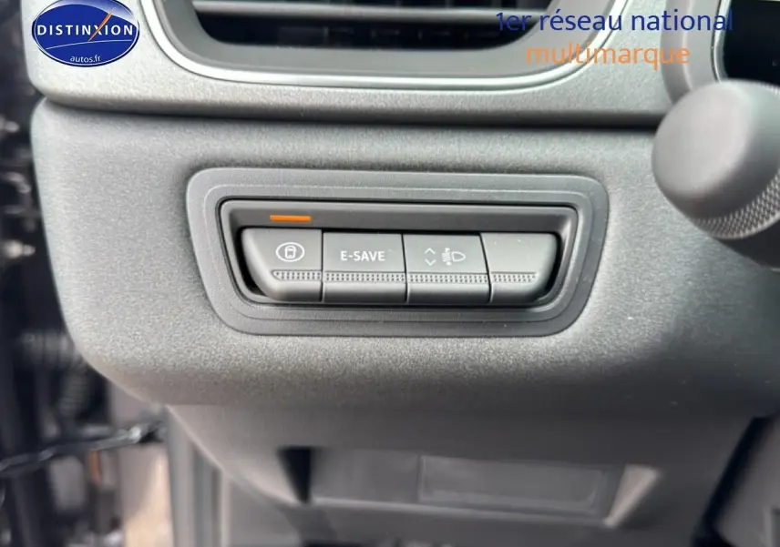 Gros plan sur les commandes E-SAVE et réglage des phares du tableau de bord gris du Renault Captur hybride 2026.