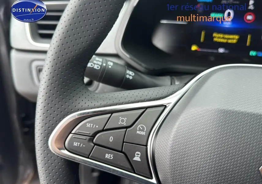 Gros plan sur les commandes multifonctions côté gauche du volant perforé d’un Renault Captur gris cassiopée 2026.