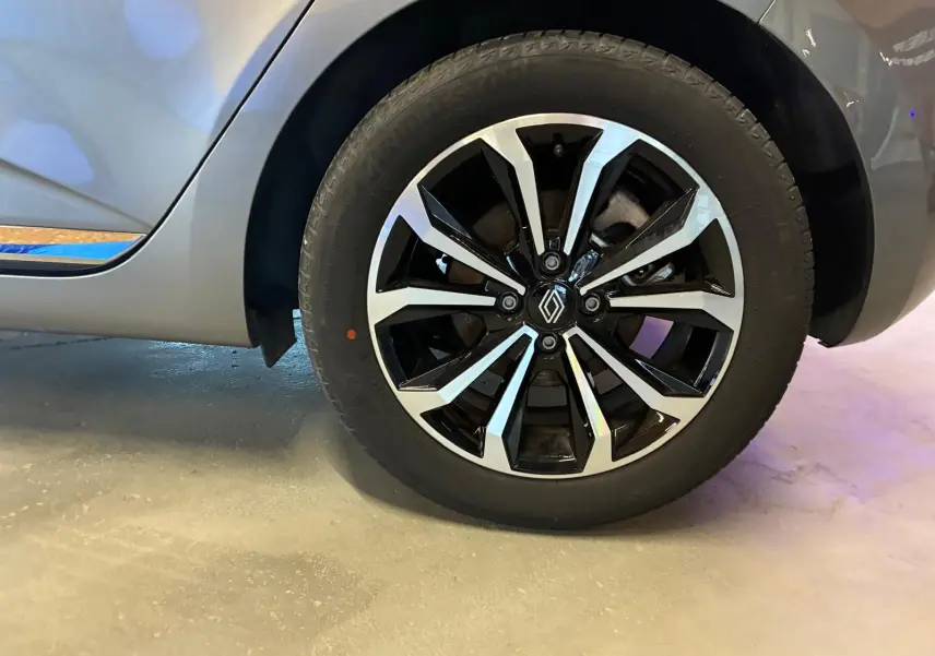 Gros plan sur la roue avant droite de la Renault Clio gris schiste 2025 avec jante alliage bicolore et logo Renault central.