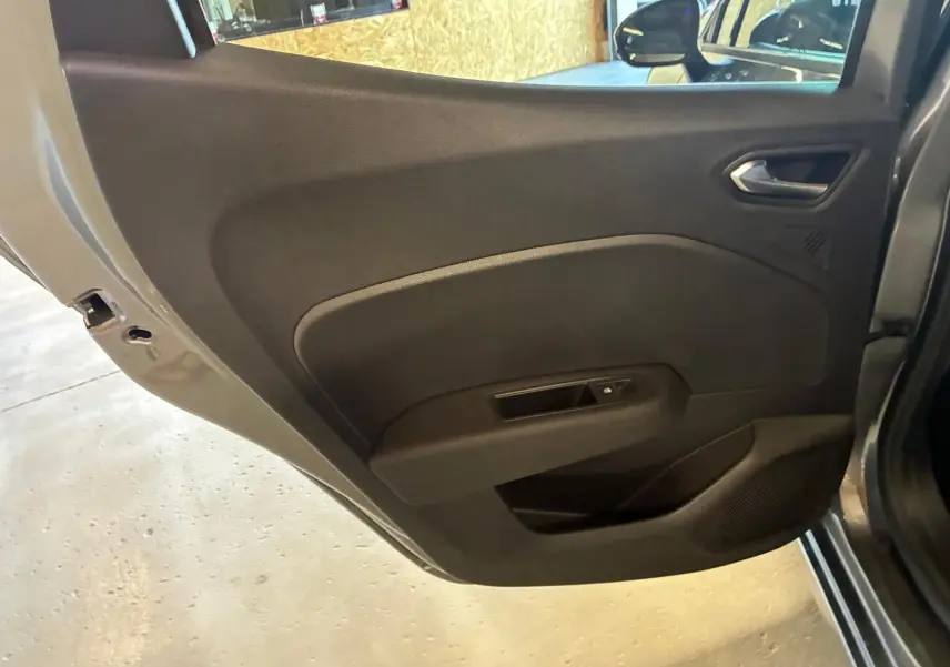 Vue rapprochée de la porte arrière gauche gris schiste de la Renault Clio 2025 avec poignée et commande de fenêtre intégrées.