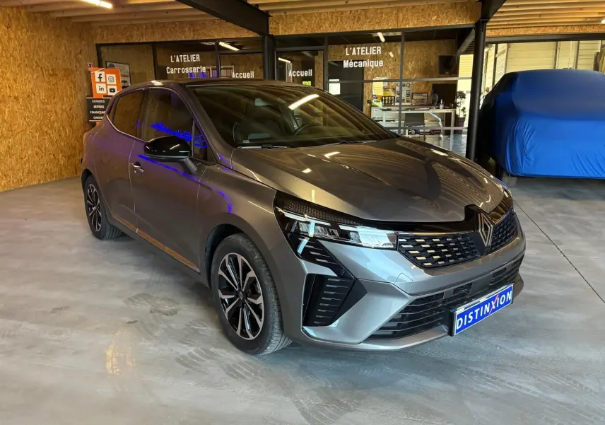 Renault Clio 2025 gris schiste vue 3/4 avant droit, avec calandre moderne et jantes alliage distinctives.