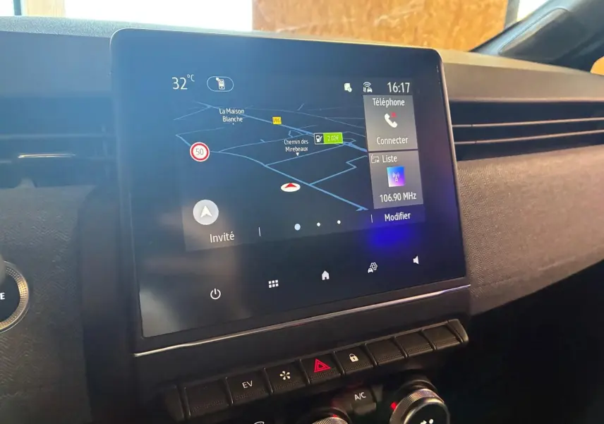 Écran tactile central avec navigation et commandes climatisation dans l'habitacle gris-noir d'une Renault Clio hybride 2025.