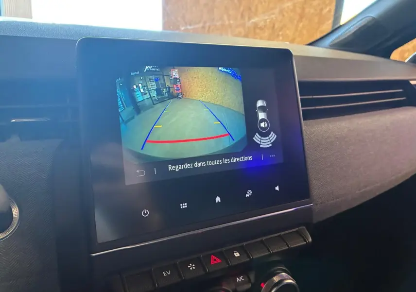 Écran tactile central affichant la caméra de recul dans l’habitacle gris-noir de la Renault Clio hybride 2025.