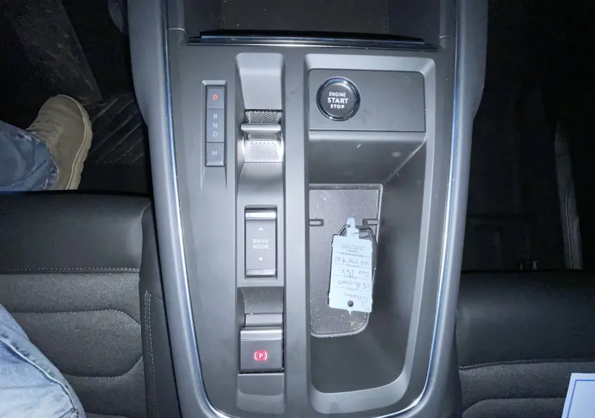 Vue plongeante sur la console centrale noire du Citroën C5 Aircross hybride 2025 avec bouton start/stop et sélecteur de vitesse.
