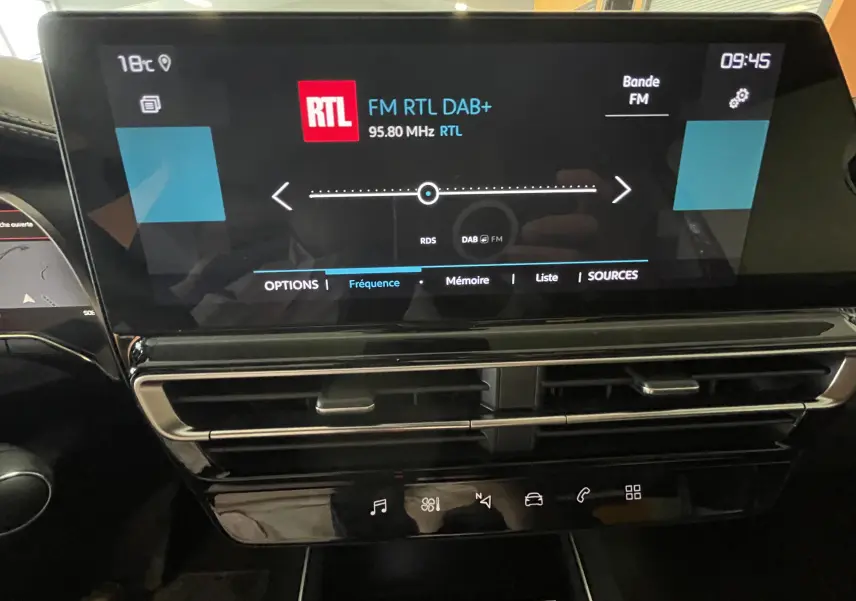 Écran tactile central du tableau de bord du Citroën C5 Aircross hybride blanc, affichant la radio RTL en intérieur.