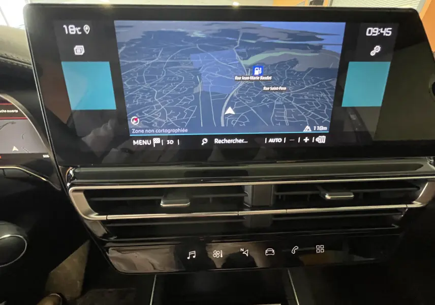 Vue rapprochée de l’écran tactile central du tableau de bord du Citroën C5 Aircross hybride 2025 affichant une carte de navigation.