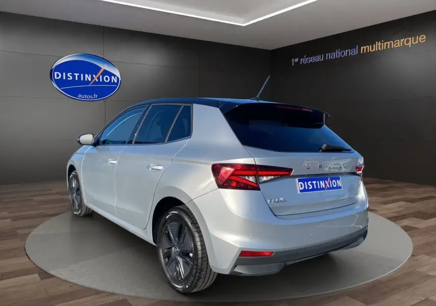 Vue 3/4 arrière droite d'une Skoda Fabia 2024 gris clair avec toit noir et jantes distinctives en concession.