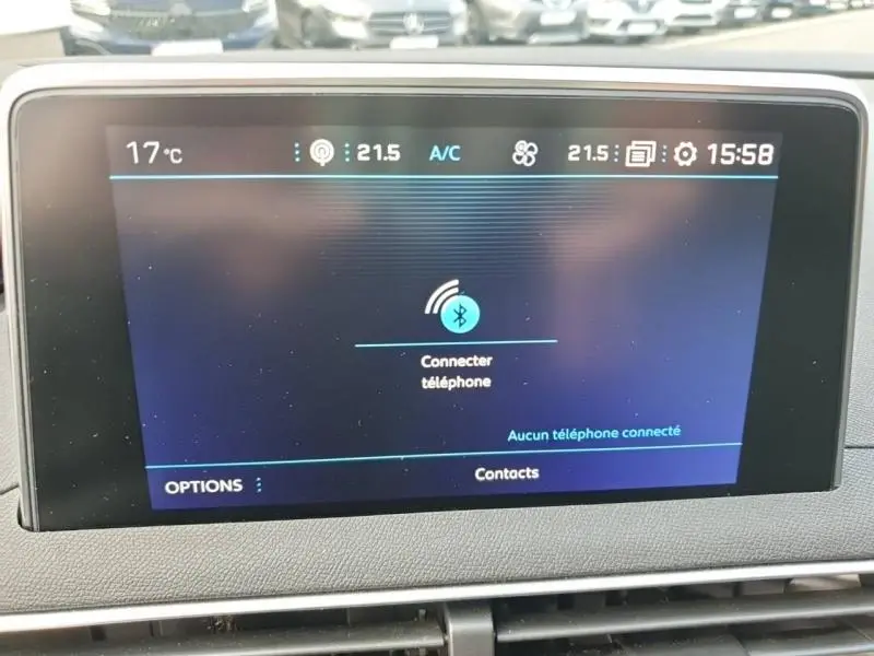 Écran tactile central du tableau de bord du Peugeot 3008 blanc nacré affichant la connexion Bluetooth au téléphone.