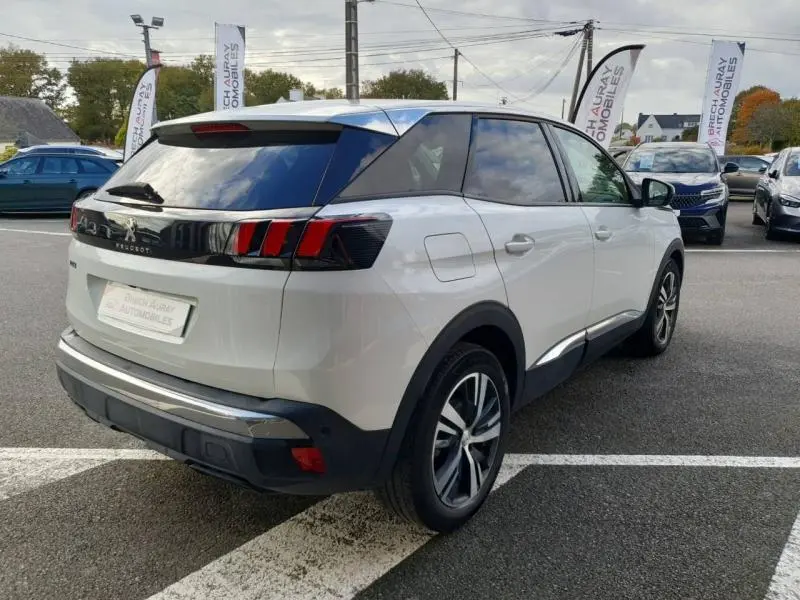 Peugeot 3008 blanc nacré vu en 3/4 arrière droit, avec feux arrière à griffes et jantes alliage.