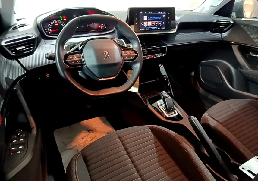 Intérieur du Peugeot 2008 2021 vu côté conducteur, volant cuir multifonctions et écran tactile central allumé.