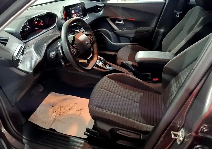 Vue intérieure côté conducteur du Peugeot 2008 gris clair 2021, volant cuir multifonctions et écran tactile central.