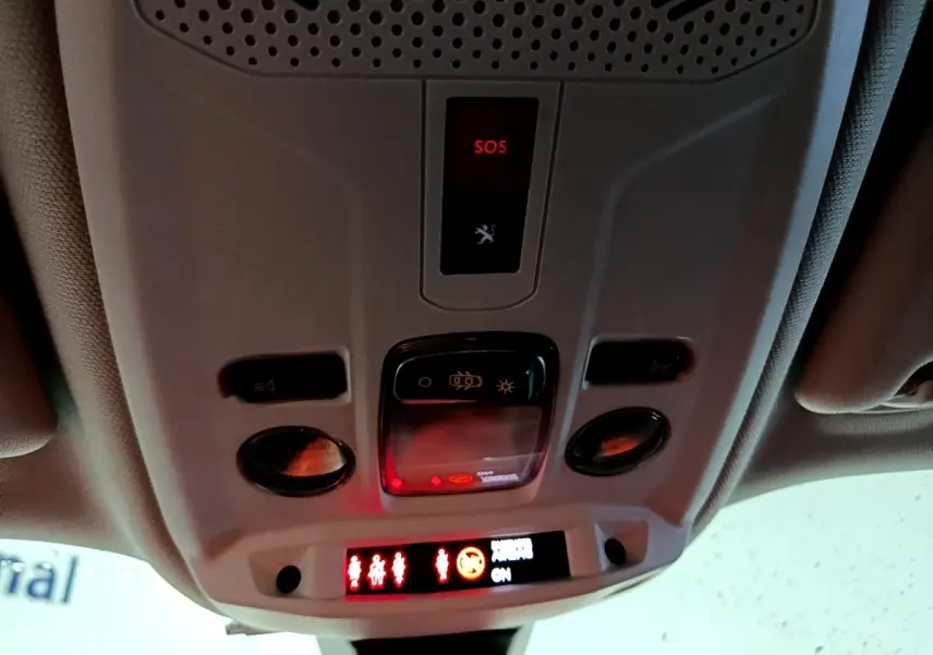 Vue intérieure du plafonnier avec boutons de commande et alerte SOS allumée dans un Peugeot 2008 gris clair.