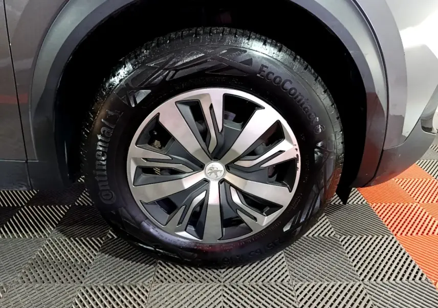Gros plan sur la roue avant droite d’un Peugeot 2008 gris clair avec jante alliage et pneu Continental EcoContact 6.