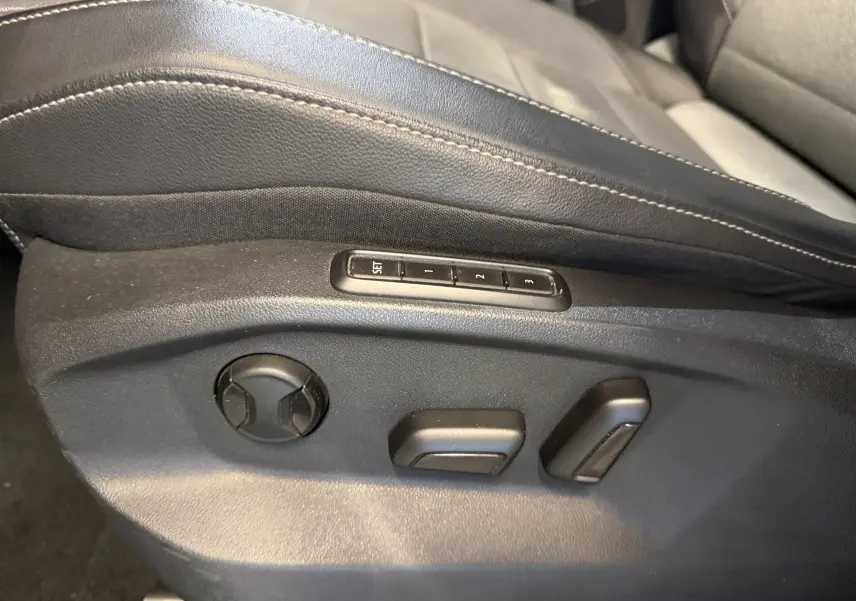 Détail des commandes électriques de réglage de siège en cuir noir sur Volkswagen T-Roc 2.0 TDI 150 DSG7 Style Exclusive.