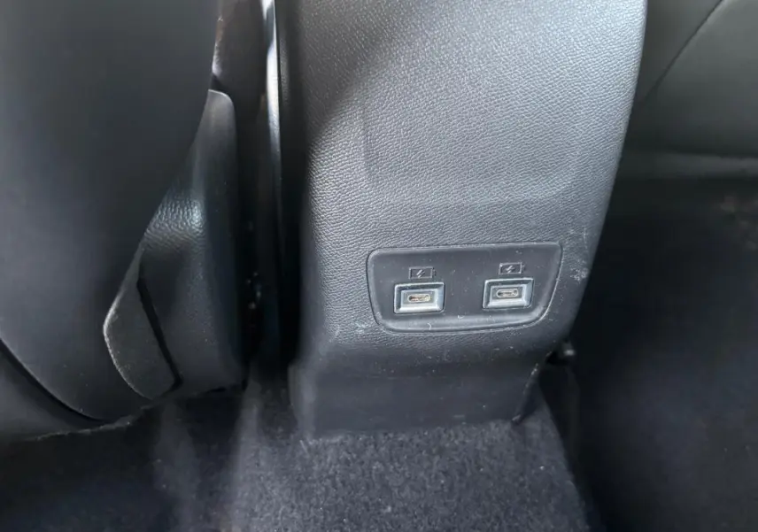 Vue rapprochée des ports USB arrière sur la console centrale d'une Lancia Ypsilon gris 2025.